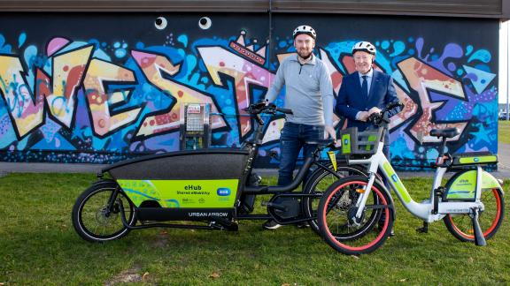 Cllr Mike Cubbard and Sean Canney TD at Westside with cargo and ebike with westside mural in background