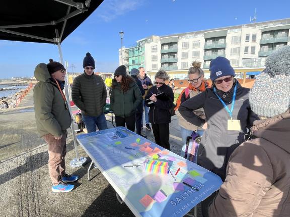 Salthill Public Consultation on Prom with people standing at table of post its with ideas written on them.