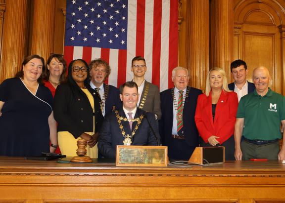 Councillors posing for picture in front of American flag