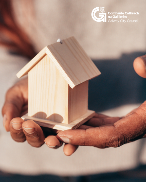 stock image of hands holding a small wooden house