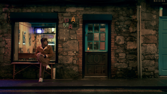 Young man sitting outside coffee shop