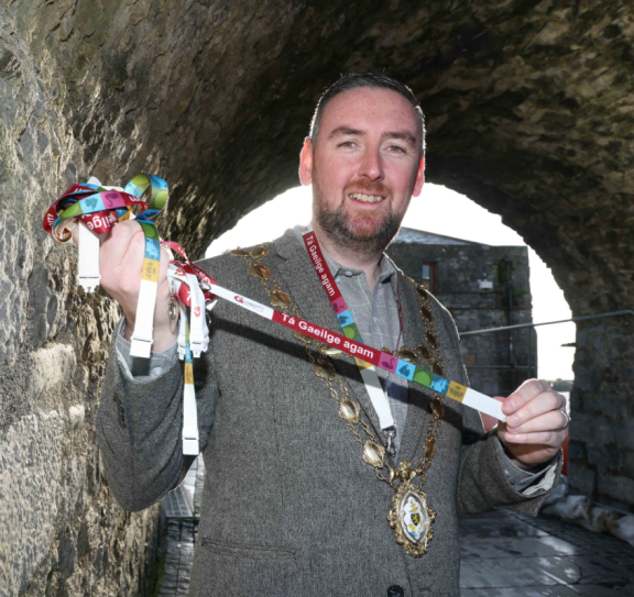 Mayor of the City of Galway, Cllr Mike Cubbard holding one of the new Gaeilge lanyards