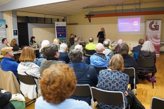 woman giving presentation in room full of people sitting down