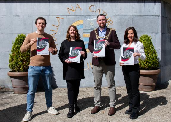 UCDO Outside City Hall holding residents handbook