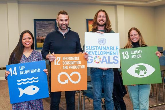 4 people holding cardboard cut outs of the UN sustainable development goals