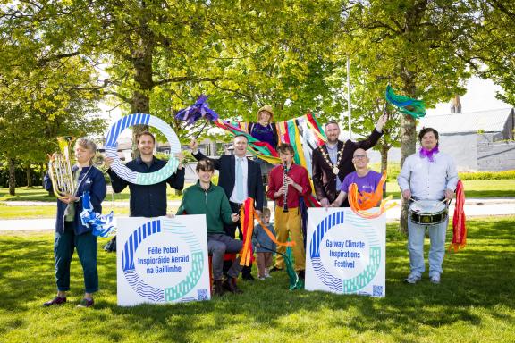 people holding signage at launch of festival in park