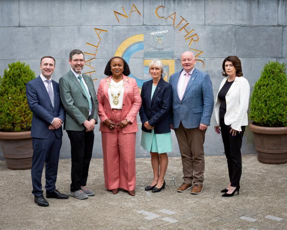 staff and delegation posing for pic outside city hall