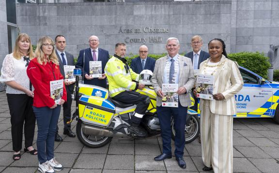 Staff and gardaí standing in front of County Hall with launched booklet