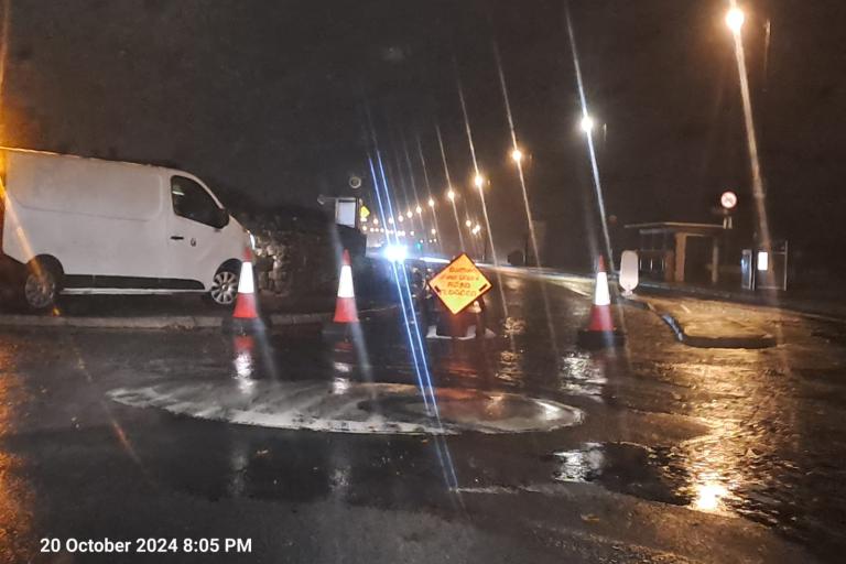Roadsigns at mini roundabout on flooded prom in Salthill