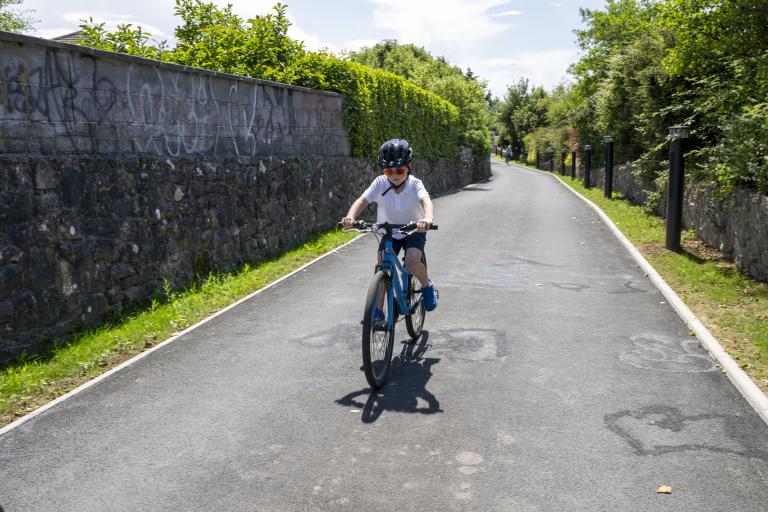 A boy in a white t-shirt cycling on the revamped Millers Lane