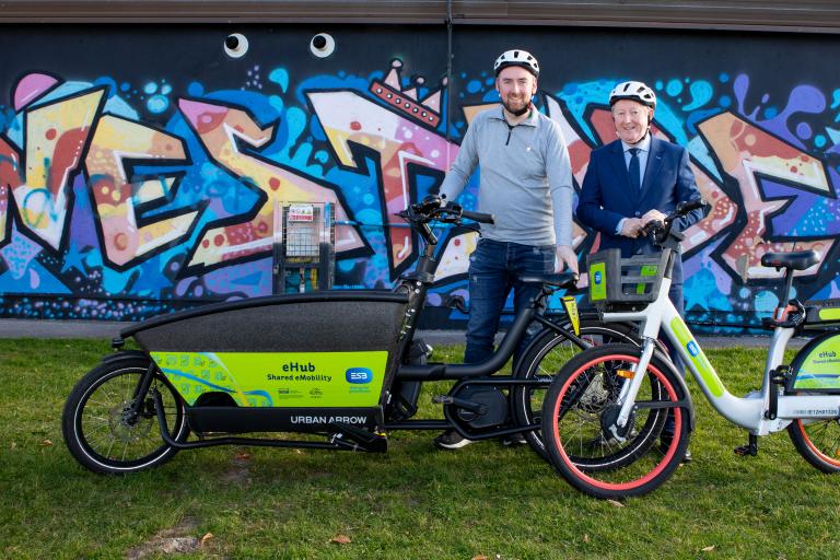 Cllr Mike Cubbard and Sean Canney TD at Westside with cargo and ebike with westside mural in background