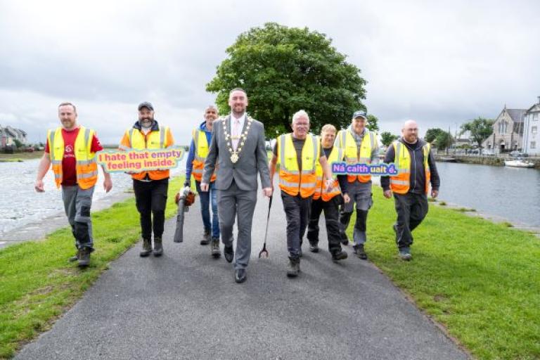Staff from the LItter Management Unit walking in a line with Mayor Mike Cubbard, at the Claddagh Basin