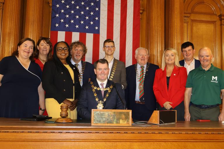Councillors posing for picture in front of American flag
