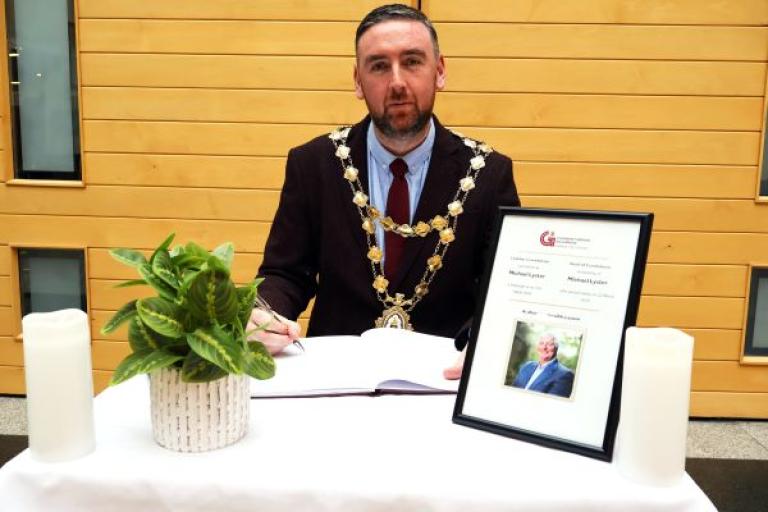 Mayor Cubbard signing the Book of Condolence for Michael Lyster