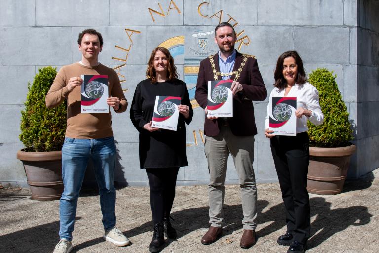 UCDO Outside City Hall holding residents handbook