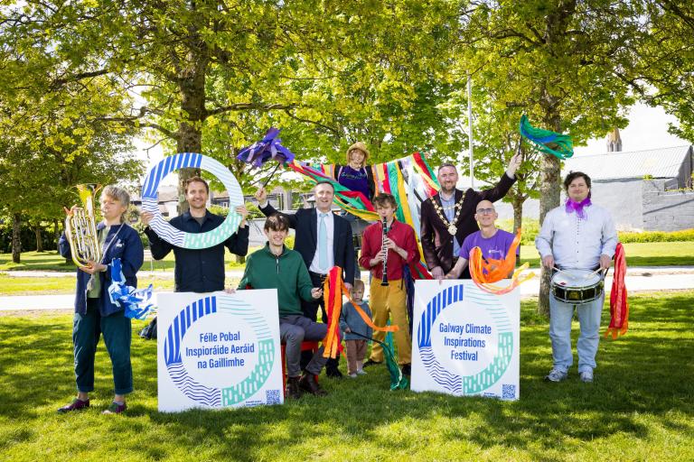 people holding signage at launch of festival in park