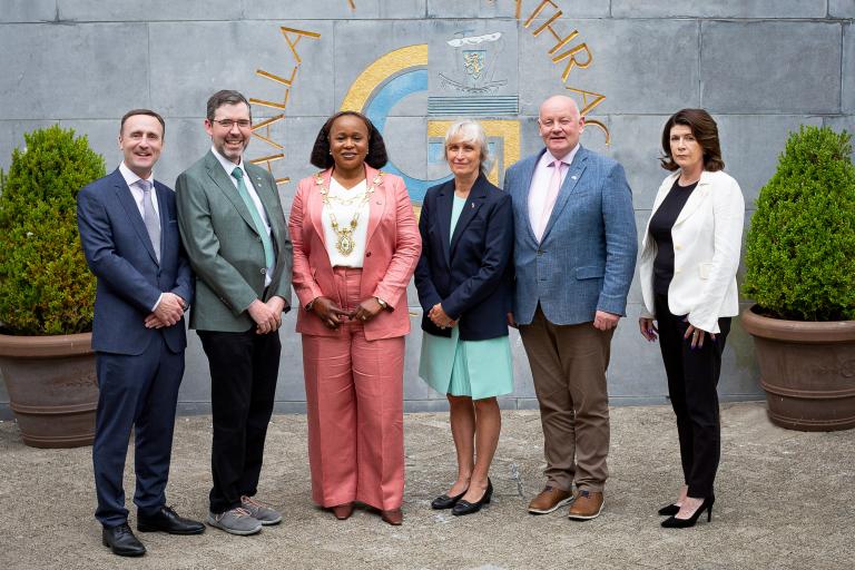 staff and delegation posing for pic outside city hall