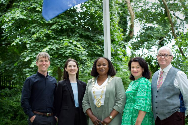 GCC Staff standing outside city hall with eu flag raised