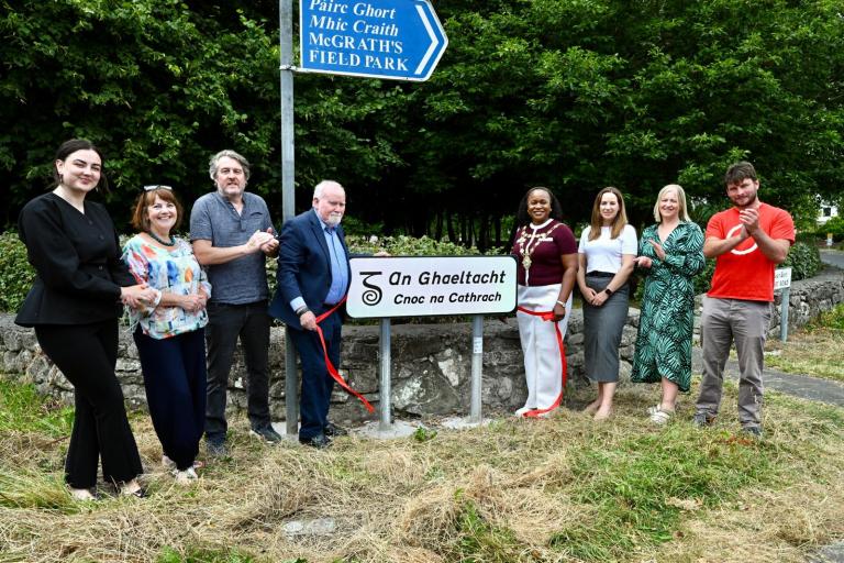 Staff and councillors standing with new an ghaeltacht sign