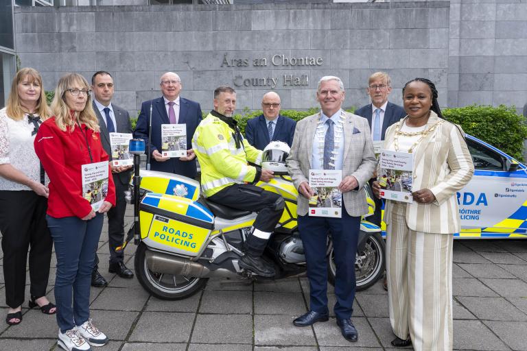Staff and gardaí standing in front of County Hall with launched booklet