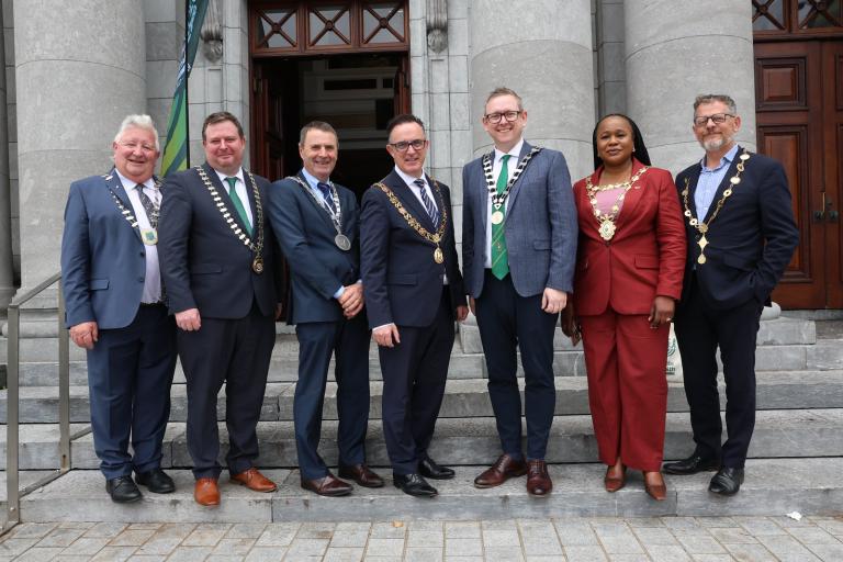 mayors standing with their chains outside a building