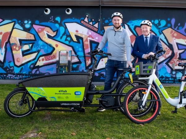 Cllr Mike Cubbard and Sean Canney TD at Westside with cargo and ebike with westside mural in background
