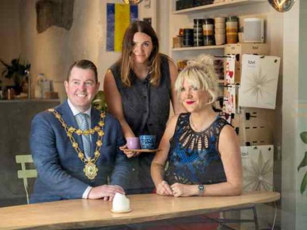 Mayor with owner of Fairhill Cafe and performer Tracy Bruen sitting in the window of Fairhill cafe