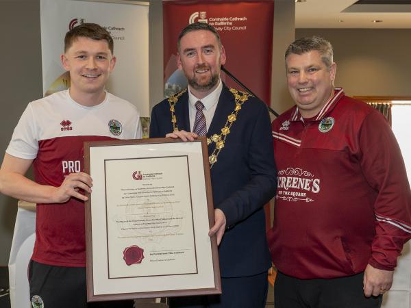 Mayor presenting certificate to two gentlemen