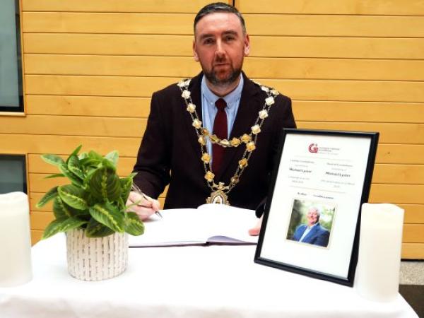 Mayor Cubbard signing the Book of Condolence for Michael Lyster