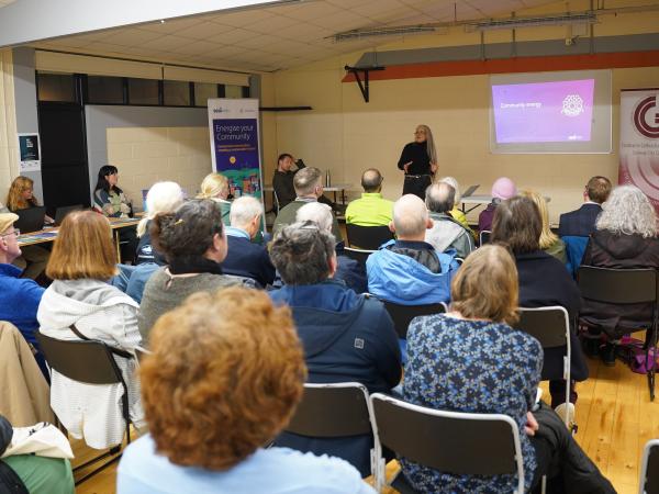 woman giving presentation in room full of people sitting down