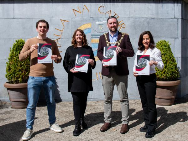 UCDO Outside City Hall holding residents handbook