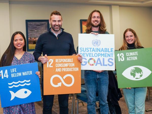 4 people holding cardboard cut outs of the UN sustainable development goals