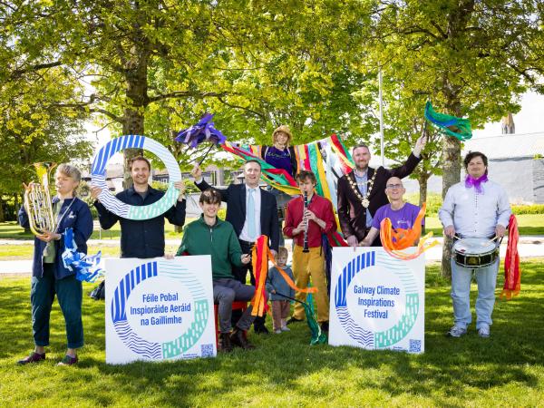 people holding signage at launch of festival in park