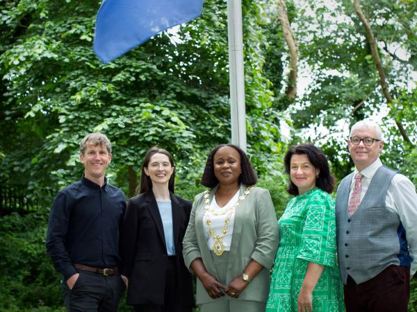 GCC Staff standing outside city hall with eu flag raised