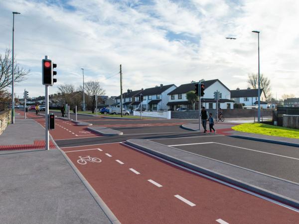 A photomontage image showing part of the future Monivea Road (East) Active Travel Scheme.  This image shows the proposed works, including the new cycle lane and people crossing at traffic lights.