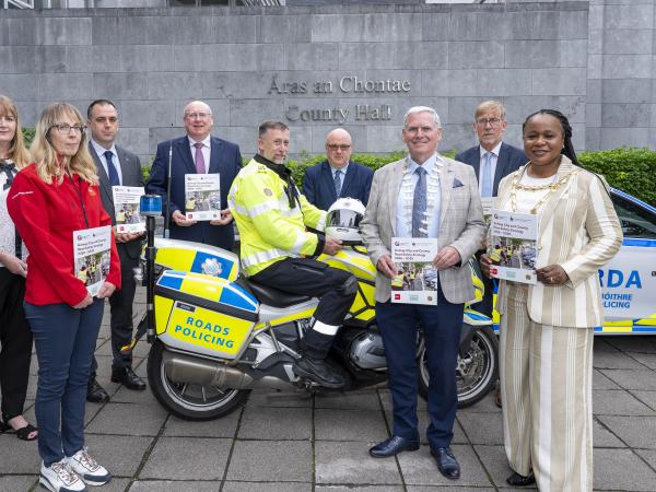 Staff and gardaí standing in front of County Hall with launched booklet